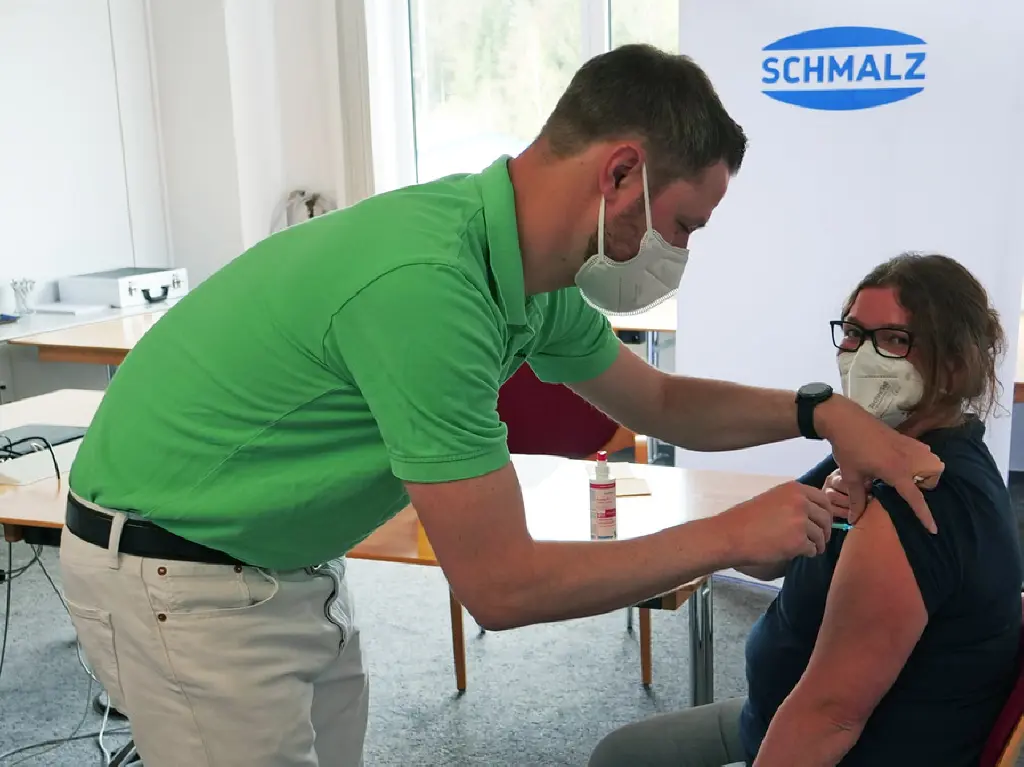 Schmalz company doctor Andreas Kreidler (left) gives employee Alexandra Würth her first company vaccination against Corona.
