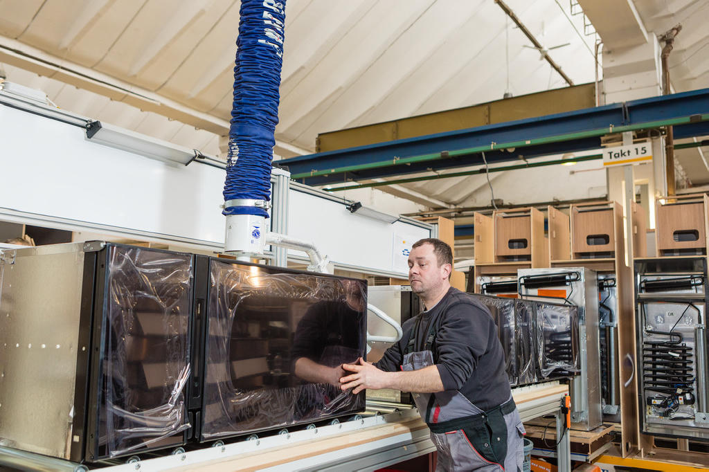 A JumboErgo is used to position the refrigerators for installation in the motorhome.