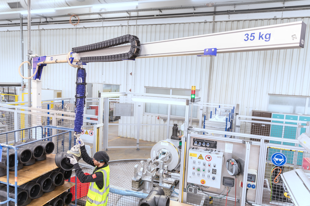 De kabelrups V-Chain pakt het slangenpakket van de vacuüm feeder in en houdt de ruimte onder de aluminium kraanarm vrij.