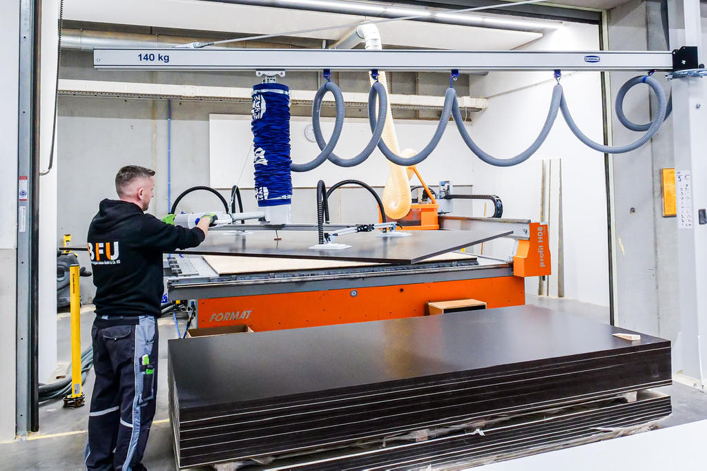 The combination of a column-mounted jib crane and a vacuum tube lifter provides the necessary flexibility for loading and unloading the machining center.